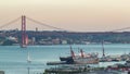 Skyline over Lisbon commercial port day to night timelapse, 25th April Bridge, containers on pier with freight cranes Royalty Free Stock Photo