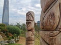 Skyline of Songdo in South Korea, wooden totem poles called jangseung in a park