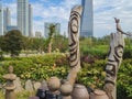 Skyline of Songdo in South Korea, wooden totem poles called jangseung in a park