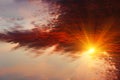 Skyline of sun rays through fiery red clouds on the sunset. Royalty Free Stock Photo