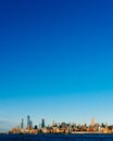 Skyline of uptown Manhattan over Hudson River under blue sky, at