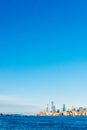 Skyline of uptown Manhattan over Hudson River under blue sky, at