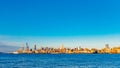 Skyline of uptown Manhattan over Hudson River under blue sky, at