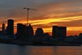 A skyline view of a city with a lifting crane in a construction site in the middle and a foreground a river, Montreal Downtown and