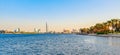 Skyline view of Dubai Creek with palms and skyscrapers from the boat tourist trip. Sunset in sunny summer day. Dubai is famous Royalty Free Stock Photo