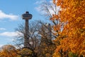 Skylon Tower, autumn maple leaves over blue sky. Fall foliage in Niagara Falls City. Royalty Free Stock Photo