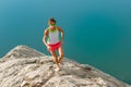 Skyrunner girl runs on a stony back over a lake Royalty Free Stock Photo