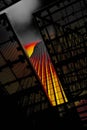 Skyscraper with a colorful sunset reflecting off its windows, framed by dark architectural elements Royalty Free Stock Photo