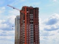 Skyscraper construction. Construction site background. Self-erecting crane with cargo near the building under construction Royalty Free Stock Photo