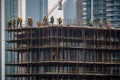 Skyscraper construction site in a major city, steel beams reaching for the sky, workers in hardhats and safety vests, and the Royalty Free Stock Photo