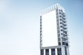 Skyscraper with empty rectangular white billboard banner on blue sky background. Public announcement and advertisement concept.