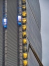 Skyscraper external elevator with persons silhouette inside