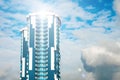 Skyscraper with a glass facade against a bright blue sky with figured clouds Royalty Free Stock Photo