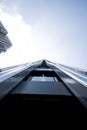 skyscraper with metal pipes and windows with a person in the middle leaning out the window looking up