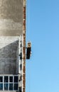 Skyscraper under construction on the background of clear blue sky with an external front elevator without people Royalty Free Stock Photo