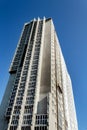 Skyscraper under construction on the background of clear blue sky with an external front elevator without people Royalty Free Stock Photo