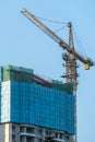 skyscraper is under construction, the crane is working under the blue sky. Royalty Free Stock Photo