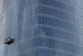 Skyscraper with washing gondola on sky background. Modern urban buildings concept. Climbing window cleaner in skyscraper.