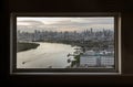 Skyscrapers along Chao phraya river in the evening time. Seen through a bedroom window frame. The beautiful view of Bangkok city Royalty Free Stock Photo