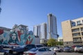 Skyscrapers, apartments and office building in the city skyline with parked cars in a parking lot and a colorful wall mural