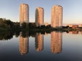 Skyscrapers on the background of the pond. Reflection of tall buildings in the lake. Modern high-rise residential buildings