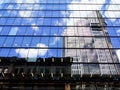 Skyscrapers, Blue Sky and Clouds Reflected in Glazed Building Facade Royalty Free Stock Photo