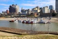 Skyscrapers and buildings in the city skyline along the water in Wolf Creek Harbor with red and white steam boats docked Royalty Free Stock Photo