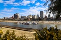 Skyscrapers and buildings in the city skyline along the water in Wolf Creek Harbor with red and white steam boats docked Royalty Free Stock Photo