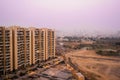 Skyscrapers in gurgaon looking out over barren land and a village Royalty Free Stock Photo