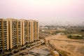 Skyscrapers in gurgaon looking out over barren land and a village Royalty Free Stock Photo