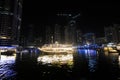 Skyscrapers illuminated by night reflected in water of canal. Dubai marina bay with yachts an boats timelapse hyperlapse Royalty Free Stock Photo