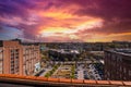 Skyscrapers and office buildings in the cityscape with powerful red and yellow sky at sunset with parked cars in a parking lot Royalty Free Stock Photo