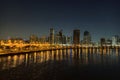 Skyscrapers are reflecting in water. Beautiful view to Sharjah city center lights skyline at night, United Arab Emirates Royalty Free Stock Photo