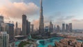 Skyscrapers rising above Dubai downtown day to night timelapse surrounded by modern buildings aerial top view