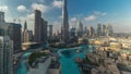 Skyscrapers rising above Dubai downtown timelapse, mall and fountain surrounded by modern buildings aerial top view