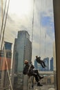 Skyscrapers window Cleaners washing a window in Doha, Qatar in blue clothes. Royalty Free Stock Photo