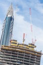 Skyscrappers construction site with cranes on top of buildings. Royalty Free Stock Photo