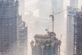 Skyscrappers construction site with cranes on top of buildings. Royalty Free Stock Photo