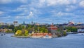 A SL public transport DJURGARDEN 9 ferry passes along islet Kastellholmen in front of small brick citadel Kastellet and vintage