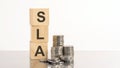 SLA - text on wooden cubes on white background with coins Royalty Free Stock Photo