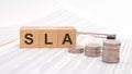 sla text is written in wooden cubes on a table with numbers with coins on a white background Royalty Free Stock Photo