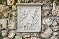 Slab with an ancient carved relief depicting a lamb of god, embedded in a stone fence of Assumption Monastery in Bakhchisarai,