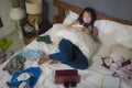 Slackness and disorganized during covid-19 home lockdown - young disorderly and chaotic Asian Chinese woman on bed using internet