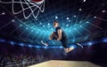 Slam dunk. Young man, professional basketball player on 3D stadium, arena during game, jumping with ball Royalty Free Stock Photo
