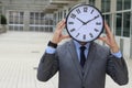 Slammed worker holding the time in front of his face Royalty Free Stock Photo