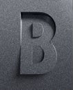 Slanted 3d font engraved and extruded from the surface, letter B