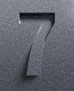 Slanted 3d font engraved and extruded from the surface, number 7