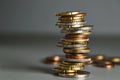 A slanted stack of coins. Euro coins stacked in a pile on the table, soft focus