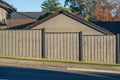Slanted street with fence and house behind it. Royalty Free Stock Photo