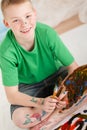 Slanted View Of Boy With Paint On Legs And Hands